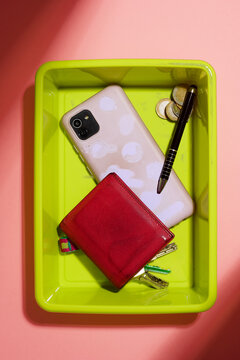 Personal belongings placed in the plastic tray at a security checkpoint.