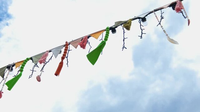 festive flags and decorations on a rope swing in the wind, slow motion
