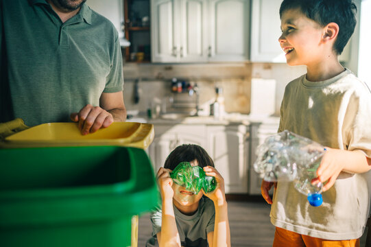 Happy family sorting plastic waste in the kitchen