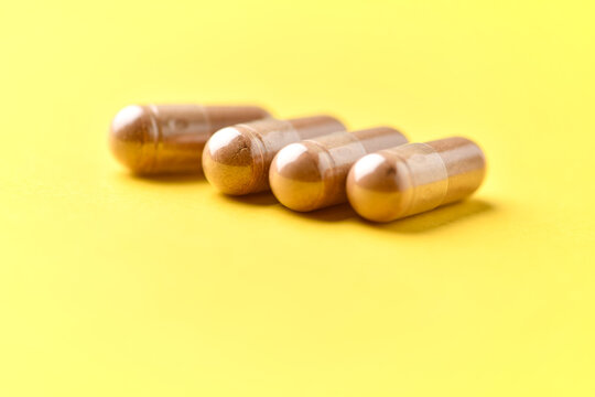 Ashwagandha (Withania somnifera) capsules. Concept for a healthy dietary supplementation. Bright paper background. Soft focus. Close up. Copy space