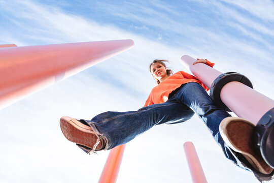 Balancing confidently on a high outdoor pole looking at camera