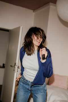 Music fan singing and dancing with a remote control in bedroom