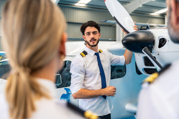 Pilot instructor explaining airplane propeller maintenance to students © unai