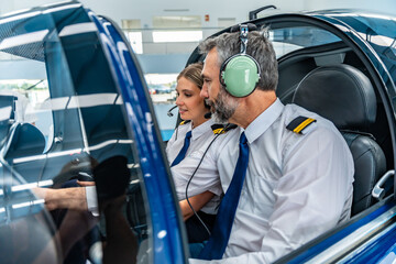 Experienced pilot mentoring young student during flight training © unai