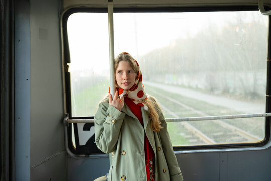 Passenger in a raincoat and headscarf commuting on a tram