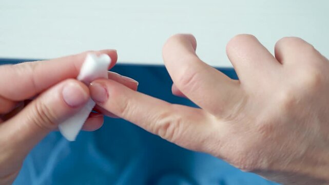Woman removing red nail polish during personal grooming routine