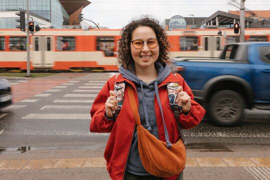 Smiling woman waiting at an urban crosswalk in the city