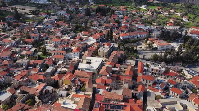Aerial drone footage captures traditional Cypriot village with terracotta roofs and narrow streets.