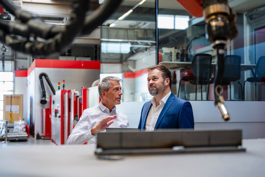 Businessman and engineer discussing automation in a factory