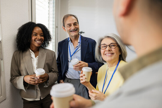 Colleagues smiling and drinking coffee during a break in the factory