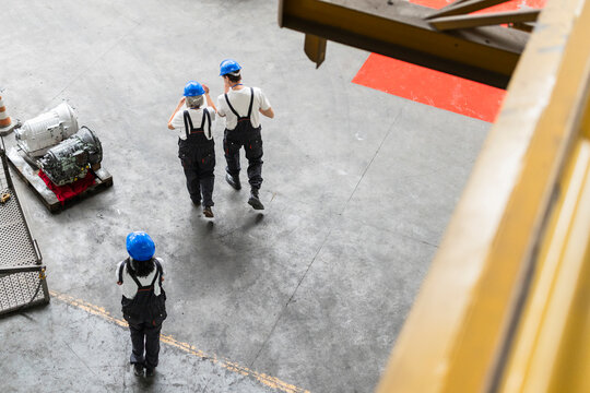 Workers and supervisor walking in an industrial warehouse facility