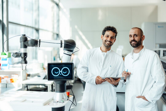 Smiling scientist and researcher working with robot in laboratory
