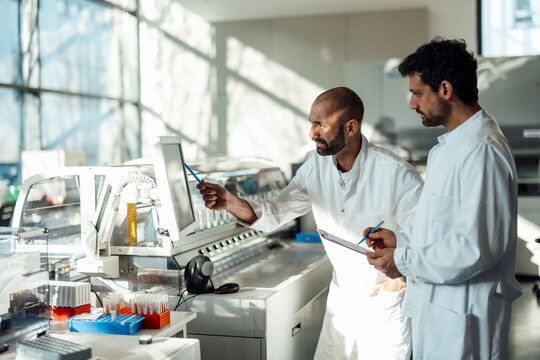 Scientists discussing results on a monitor in a high-tech laboratory