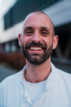 Smiling doctor wearing uniform looking at camera outdoors