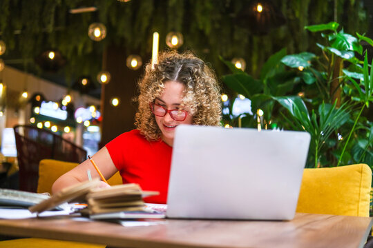 Architect working on blueprint with laptop in green office