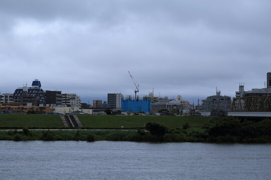 台風通過後の雨雲 暴風雨後の河川と都市風景 / Heavy overcast sky over a river and city buildings after a tropical typhoon