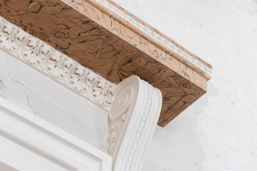 Fototapeta premium Close-up of an ornate marble cornice and decorative plaster column showcasing classical scrollwork, carved acanthus motifs and textured molding in a bright historic interior space