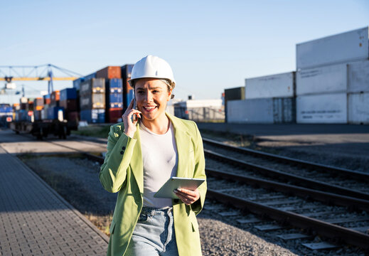 Logistics supervisor talking on phone at a shipping port