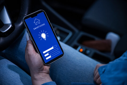 Holding smartphone with smart home app inside a car