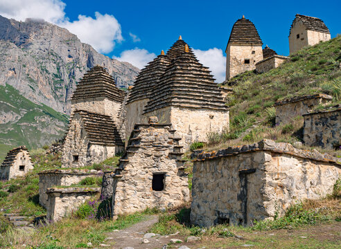 Ancient stone crypts on a green mountain slope in the City of the Dead Dargavs, Russia