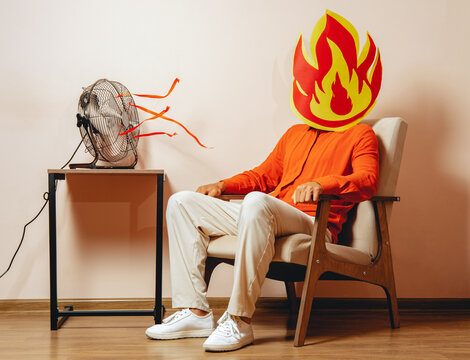 Man with flame mask in armchair by fan experiencing burnout