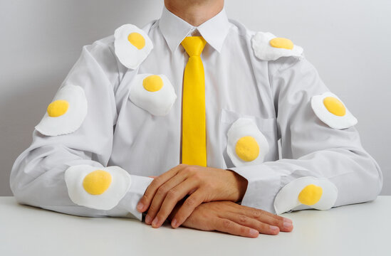 Office worker in white shirt with fried egg decorations and yellow tie