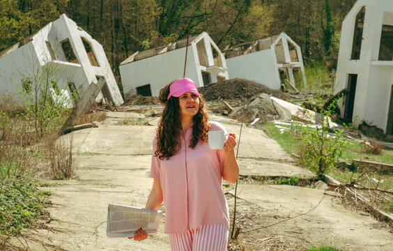 In pajama with morning coffee and newspaper amidst destruction