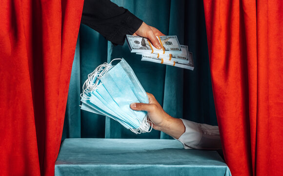 Hand exchanging money for medical mask on a theater stage
