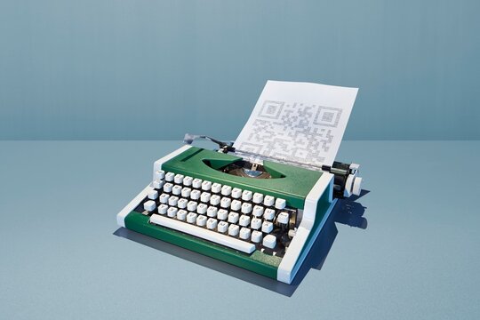 Green retro typewriter printing a modern QR code on paper