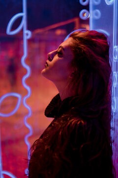 Dreamy portrait in profile illuminated by glowing neon light