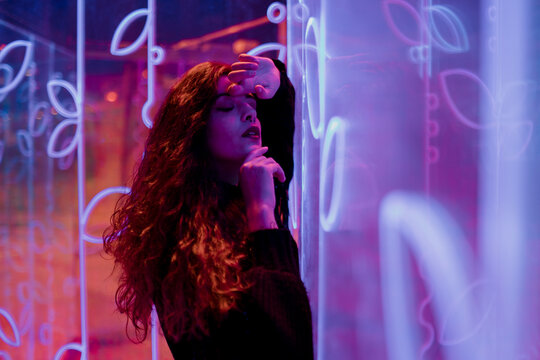 Fashion portrait with sensual pose in dramatic neon lighting