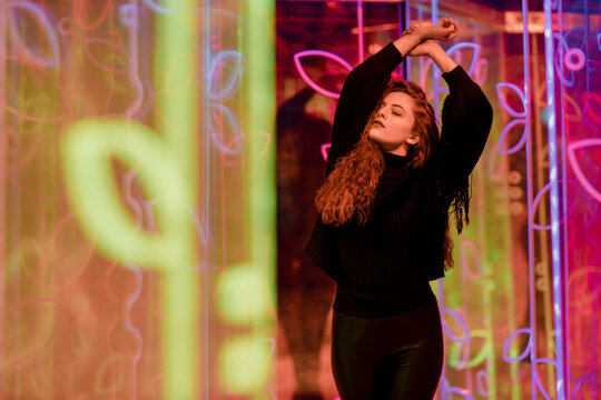 Expressive dancing in a vibrant neon light art installation