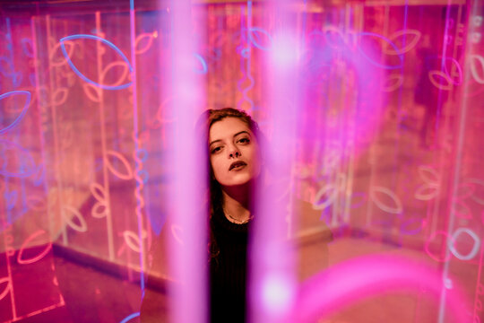 Creative portrait surrounded by glowing pink neon pattern