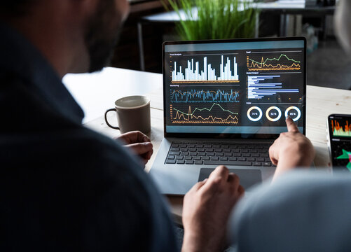 Colleagues discussing financial data on a laptop in the office