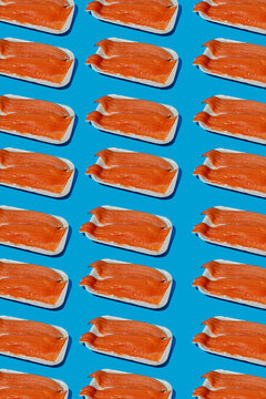 Geometric pattern of raw packaged trout on blue background