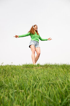 Dancing to music with headphones in a grassy field in Spain