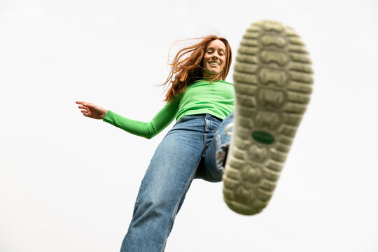 Low angle view of a stepping shoe with red hair and green shirt