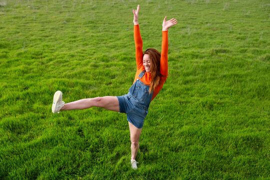 Joyful individual balancing in a grassy field in Spain