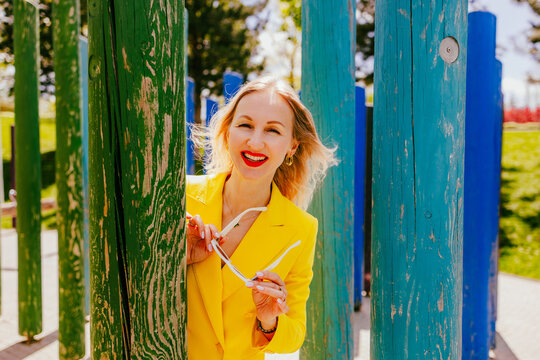 Happy freelancer relaxing by colored pillars in a modern park