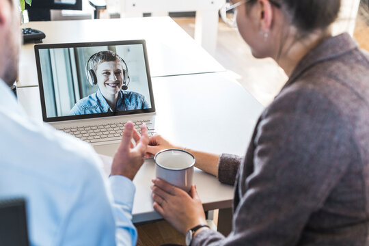 Colleagues having a videocall meeting on a laptop in the office