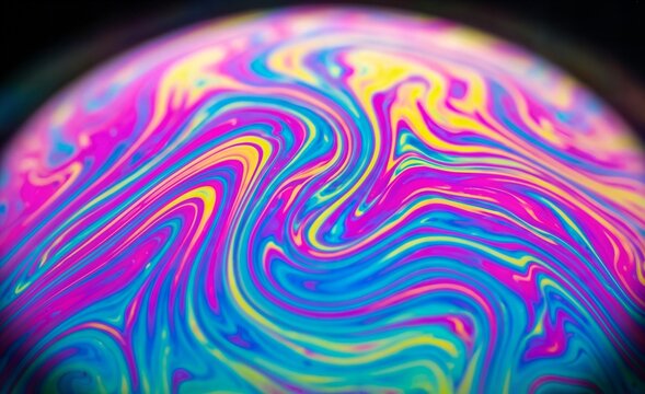 Close up of a vibrant colorful soap bubble surface with swirling psychedelic patterns and iridescent textures reflecting light and creating an abstract display.