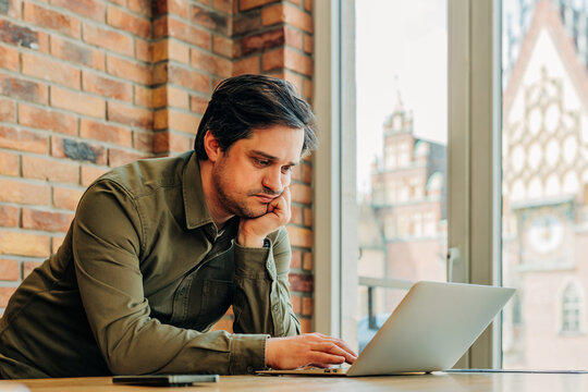 Businessman working on laptop in modern office cafe