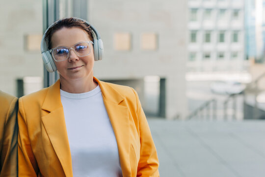 Businesswoman relaxing with music outdoors in the city