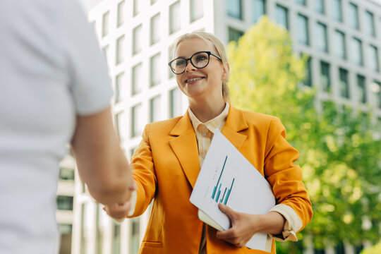 Smiling manager shaking hands with colleague outdoors