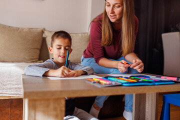 Naklejka premium Mother and son having fun drawing at home