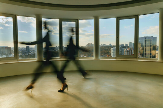 Motion blurred executives walking in a modern office