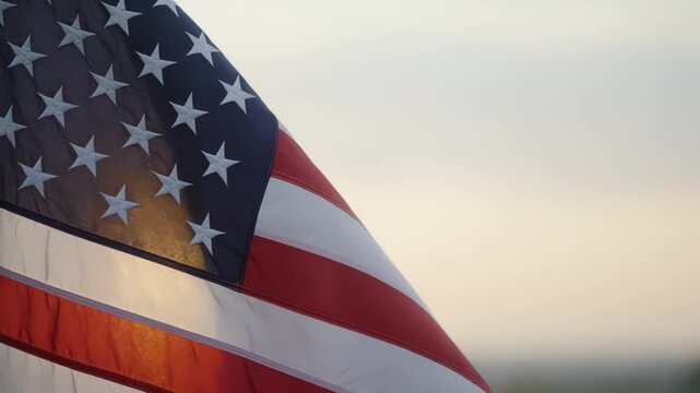 American flag moving softly at sunrise in cinematic slow motion with patriotic morning light for remembrance editorial footage