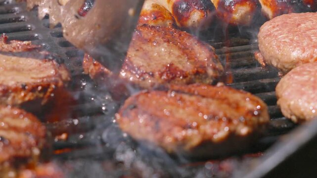 Beef Burger Flipped in Slow Motion on Hot BBQ with Flames Erupting. Perfect for food commercials, summer cooking, and restaurant marketing. 4K.
