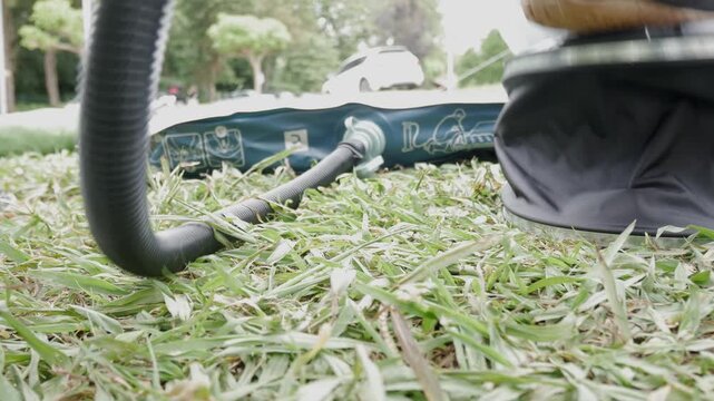 Foot presses pump to inflate air mattress on grass during outdoor setup