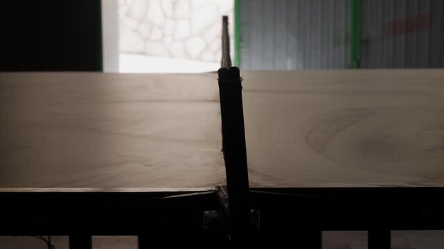 Silhouette of an indoor ping pong table with net, seen from a low center angle